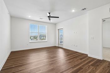 Empty bedroom with ceiling fan and balcony access